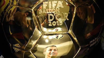 A picture taken on December 15, 2015 shows (from left) images of Barcelona's Brazilian forward Neymar, Real Madrid's Portuguese forward Cristiano Ronaldo and Barcelona's Argentinian forward Lionel Messi, reflecting into the Ballon d'Or 2015 trophy displayed at the Mellerio jewelery workshops in Paris. The Ballon d'Or 2015, Fifa's annual football award given to the male player considered to have performed the best in the previous calendar year, will be awarded on January 11, 2016 during a gala event in Zurich. / AFP / FRANCK FIFE