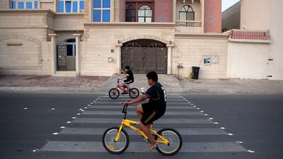 Two boys enjoy the simple pleasures of ice cream, bikes and friendship in Al Zaab, Abu Dhabi. The neighbourhood was established in the 1960s by the late President Sheikh Zayed.