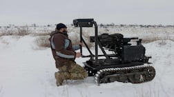 A Ukrainian serviceman with a robotic combat vehicle armed with an Mk 19 grenade launcher. Robots now dominate the front line, Ukraine's former military chief has said. AFP