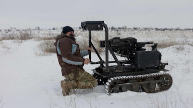 A Ukrainian serviceman with a robotic combat vehicle armed with an Mk 19 grenade launcher. Robots now dominate the front line, Ukraine's former military chief has said. AFP