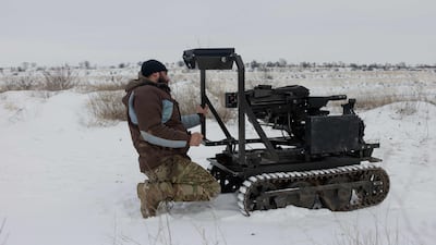 A Ukrainian serviceman with a robotic combat vehicle armed with an Mk 19 grenade launcher. Robots now dominate the front line, Ukraine's former military chief has said. AFP