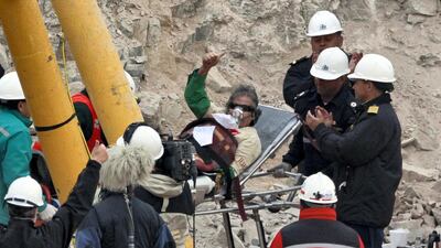 Miner Mario Gomez, 63, the oldest of the 33 trapped miners, celebrates as he is wheeled into the field hospital for a check-up after arriving on the surface as the ninth to be rescued in Copiapo October 13, 2010. Chile's 33 trapped miners are set to travel nearly half a mile through solid rock in a shaft just wider than a man's shoulders on Tuesday night, as their two month ordeal after a cave-in draws to an end. REUTERS