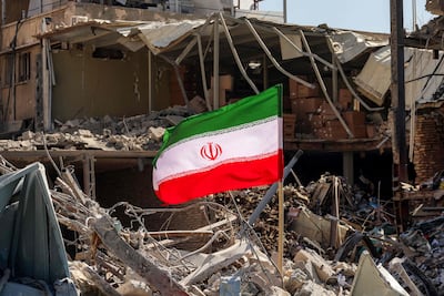 An Iranian flag among rubble and debris next to a destroyed residential building near Ferdowsi Square in Tehran on March 3. AFP