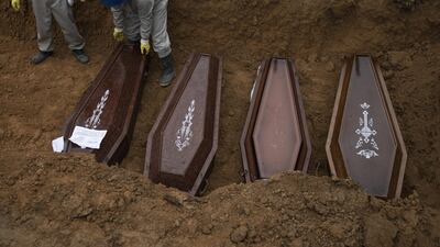 Cemetery workers place coffins in a common grave during a funeral at the Nossa Senhora Aparecida cemetery, amid the new coronavirus pandemic in Manaus, Brazil, Wednesday, May 13, 2020. AP Photo