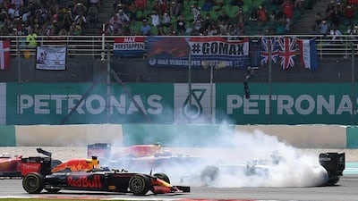 Mercedes-GP driver Nico Rosberg, right, faces the wrong direction after spinning at the start of the race. Manan Vatsyayana / AFP