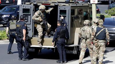 Heavily armed law enforcement personnel exit an armored vehicle outside the San Bruno building. AP Photo/Marcio Jose Sanchez