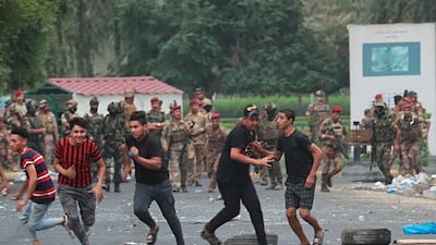 Iraqi security forces chase anti-government protesters in Baghdad, Iraq. AP Photo