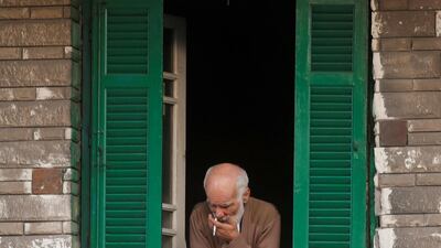 An Egyptian man looks from the window of his home as he smokes a cigarette in Alexandria, Egypt. Reuters