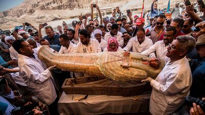 Egyptian archeologists open a wooden coffin belonging to a man in front Hatshepsut Temple at Valley of the Kings in Luxor. AFP