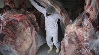 A man delivers sides of beef to a butcher shop in Brasilia. The European Union, mainland China and Chile have halted some meat imports from Brazil, a major blow to the country that is among the world’s largest exporters of meat. Eraldo Peres / AP Photo