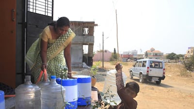 Promodini Jhamble, left, sells purified water to homes and shops nearby. Subhash Sharma for The National