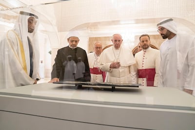 ABU DHABI, UNITED ARAB EMIRATES - February 4, 2019: Day two of the UAE papal visit - HH Sheikh Mohamed bin Zayed Al Nahyan, Crown Prince of Abu Dhabi and Deputy Supreme Commander of the UAE Armed Forces (L), His Eminence Dr Ahmad Al Tayyeb, Grand Imam of the Al Azhar Al Sharif (centre L), His Holiness Pope Francis, Head of the Catholic Church (centre R), and HE Mohamed Khalifa Al Mubarak, Chairman of the Department of Culture and Tourism and Abu Dhabi Executive Council Member (R), look at leaves from the Blue Qurían courtesy of Zayed National Museum, during a dinner reception at Al Mushrif Palace. ( Ryan Carter / Ministry of Presidential Affairs ) ---