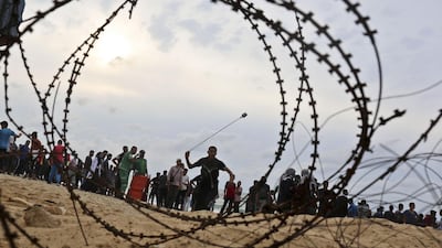 A young Palestinian throws a stone towards Israeli forces near the maritime border with Israel during the Great March of Return protests. AFP / Said Khatib