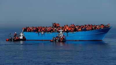 Migrants on a wooden boat are rescued by the Malta-based NGO Migrant Offshore Aid Station (MOAS) in the central Mediterranean in international waters off the coast of Sabratha in Libya on April 15, 2017. Darrin Zammit Lupi / Reuters, file