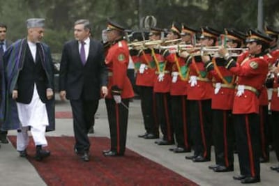 Former Afghan and UK leaders Hamid Karzai and Gordon Brown inspect a guard of honour in Kabul in 2009. Getty