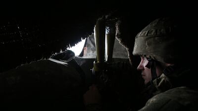 A Ukrainian Military Forces serviceman looks through a spyglass on the front line with Russia-backed separatists not far from Novolugansk in the Donetsk region. AFP