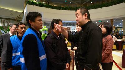 A relative of passengers on missing Malaysia Airlines flight MH370 questions an aid worker from Malaysia at restaurant in a hotel in Beijing. Relatives of Chinese passengers on Malaysia Airlines flight MH370 were still clutching to faint straws of hope for their loved ones, four days after the aircraft went missing. Wang Zhao / AFP Photo March 11