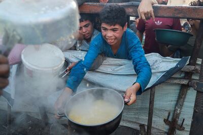 A boy receives food from a charity kitchen in Gaza city, amid a hunger crisis. Reuters