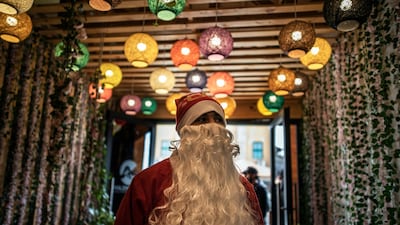 A Palestinian waiter dressed as Santa Claus welcomes visitors at the entrance of a restaurant on the beach in Gaza City. AP