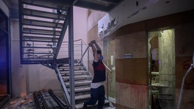 A protester strikes a wall with a metal bar inside the Lebanese Banks Association (ABL) headquarters. Bloomberg