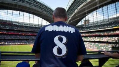 Milwaukee Brewers' fan Bryan Von Declan has the name of suspended player Ryan Braun covered up in his shirt as he takes his seat.