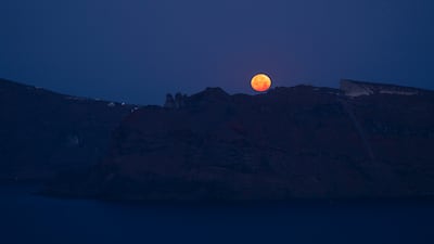 The strawberry supermoon sets in the Aegean Sea, behind Thirasia, an island in the volcanic island group of Santorini in Greece's Cyclades. AP Photo