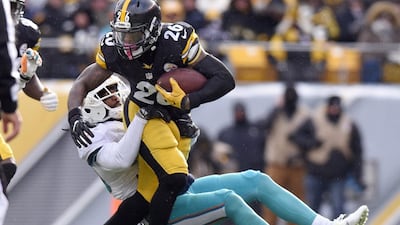 Pittsburgh Steelers running back Le’Veon Bell runs through an attempted tackle by Miami Dolphins free safety Bacarri Rambo in Pittsburgh, Pennsylvania, on January 8, 2017. Don Wright / AP Photo