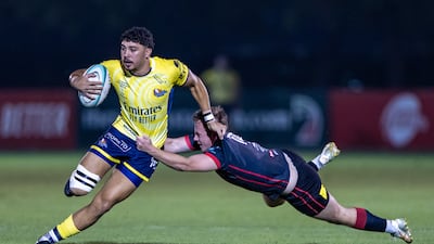Aaron Dubois of Dubai Hurricanes is tackled by Lewis Burns of Dubai Exiles.