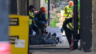 Emergency workers near the body of someone killed in Yehud, Israel, where shrapnel from a projectile had fallen. Getty Images