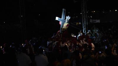 A light illuminates the statue of the Black Nazarene as it is carried on a carriage at the start of an annual religious procession. AFP