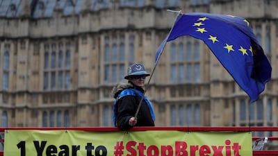 Anti-Brexit demonstrators wave European Union flags from the top deck of a bus parked outside the Houses of Parliament in London. AFP