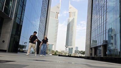 People walk near the main gate of the Dubai International Financial Centre in Dubai on Monday. EPA