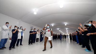 Medical staff at Dubai Parks and Resort field hospital cheer as their final 17 coronavirus patients are discharged. Chris Whiteoak / The National