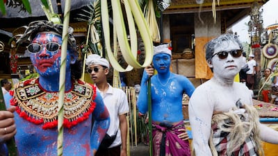 People in traditional costume and body paint take part in the Ngerebeg ritual to ward of evil spirits in Tegallalang, Bali, Indonesia. EPA