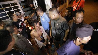 A shirtless Filipino man is brought to police station on June 8, 2016 as part of Oplan Rody, president-in-waiting Rodrigo Duterte's anti-crime operation in Manila. Aaron Favila / Associated Press