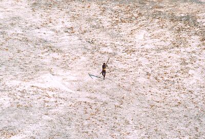 A Sentinelese man aims his bow and arrow at a coast guard helicopter surveying damage caused by a tsunami in India's Andaman and Nicobar archipelago in December 2004. Reuters