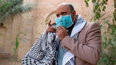 Iraqi actor Mohammad Qassem, the main character of a parody sketch video of Bab al-Hara, an adaptation of an iconic long-running Syrian television drama, adjusts his face mask while acting on set in Iraq's southern port city of Basra on April 22, 2020. Artists in Iraq's southern port city of Basra have adapted the beloved characters of "Bab al-Hara" - the 10-season period drama watched across the Arab world -- to convince their compatriots to take the COVID-19 coronavirus pandemic seriously. The language of comedy could convince people to take preventative action against the virus in ways government orders could not. AFP / Hussein Faleh