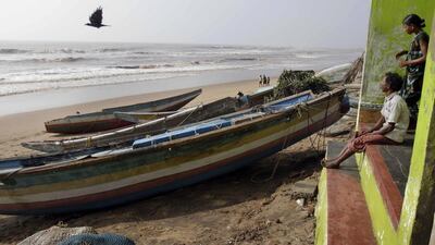 An Indian fisherman with his wife look at the sea on the Bay of Bengal coast after returning to Pudumpeta village in Ganjam district, Orissa state, India following a cyclone. Bikas Das / AP Photo