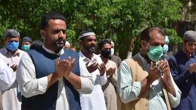 Pakistani paramedics and people pray over a colleague who died due to Covid-19 in Quetta. AFP