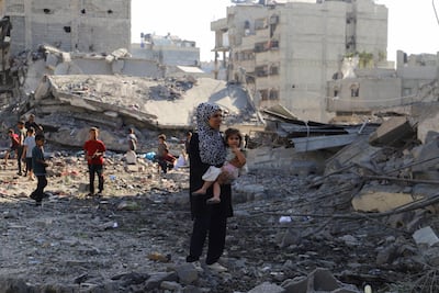 A Palestinian woman and children at the site of an overnight Israeli strike on a house in Gaza city. Reuters