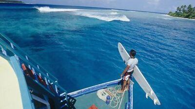 A surfer scouts for a spot to get in the water. Courtesy Visit Maldives