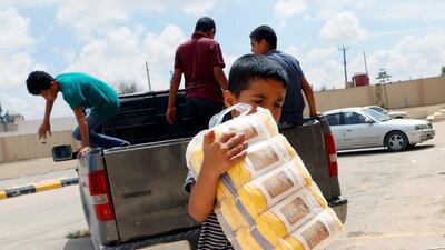 Displaced Libyan people receive aid and supplies outside a hotel used as a shelter, in Tajura neighborhood, east of Tripoli, Libya. Reuters