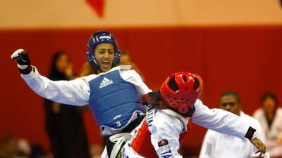 Abu Dhabi, UAE, Sept. 24, 2010, Women's Taekwondo Championship-(Blue Head Gear) Basma Essa reacts to her head kick to Zawan Zaid (Red Head Gear) during the elimination rounds of the Women's Taekwondo Championship. . Mike Young / The National