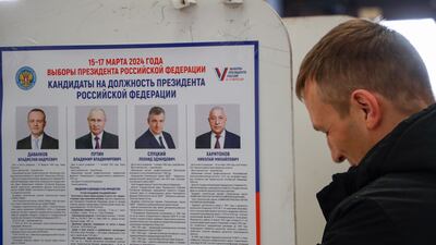 A poster shows the candidates in Russia's presidential elections at a polling station in Moscow. EPA