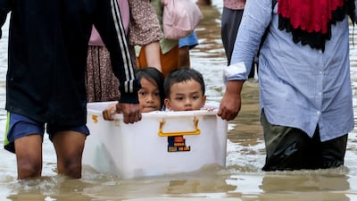 Indonesian residents leave a flooded area in Deli Serdang in the country's North Sumatra province. Reuters