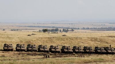 Israeli soldiers walk past tanks near the border with Syria in the Israeli-occupied Golan Heights, Israel May 11, 2018. REUTERS/Baz Ratner