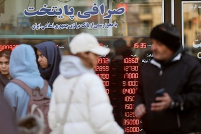 People walk past a display sign at a currency exchange bureau in Tehran. Reuters