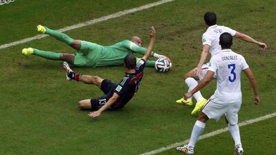 Goalkeeper Tim Howard of the US saves the ball in front of Germany's Thomas Muller during their match on Thursday at the 2014 World Cup. Ruben Sprich / Reuters
