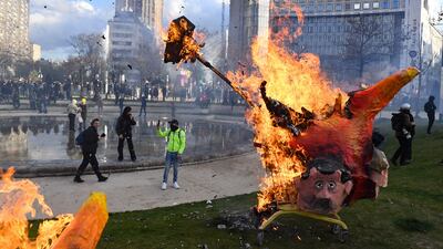 Protesters burn an effigy of French President Emmanuel Macron during a demonstration at Place d'Italie, Paris, after the government pushed for pension reforms without a vote. AFP