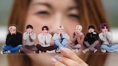 A fan of K-pop band BTS poses with a photo of the group during the annual BTS Festa, in Goyang, South Korea. AP